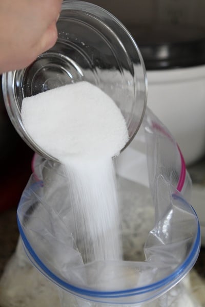 Sugar poured into a Ziplock bag filled with biscuit dough pieces.