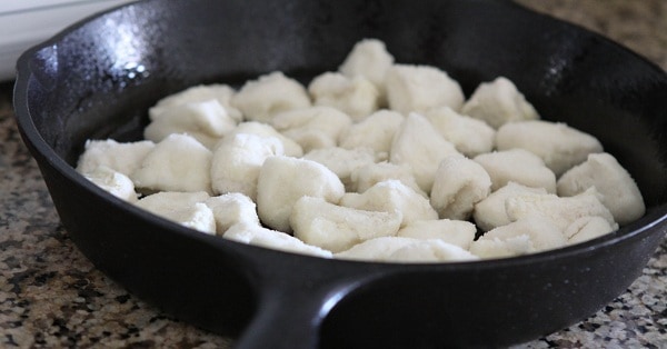 Sugar coated biscuit dough pieces in a cast iron skillet.
