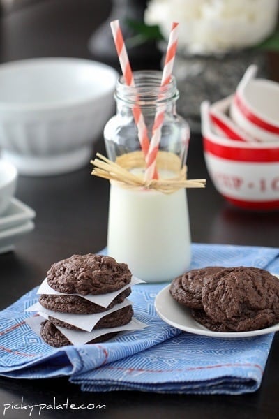 Bakery Style Cookies & Cream Cookies on a Dish Towel Next to a Cold Cup of Milk