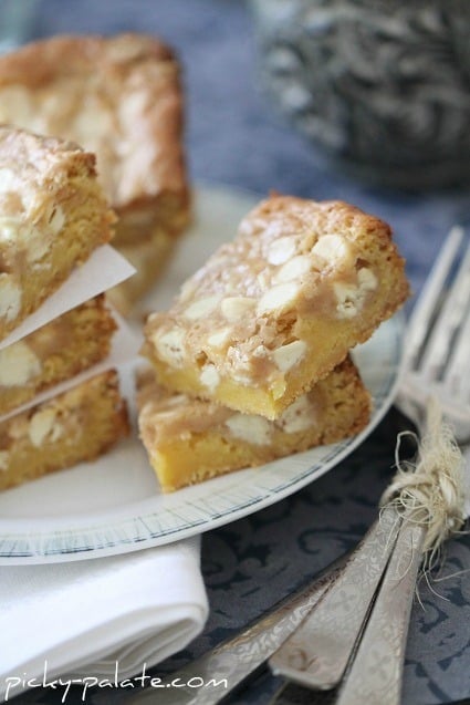 Image of Gooey White Chocolate Fluffernutter Cake Bars Piled on a Plate
