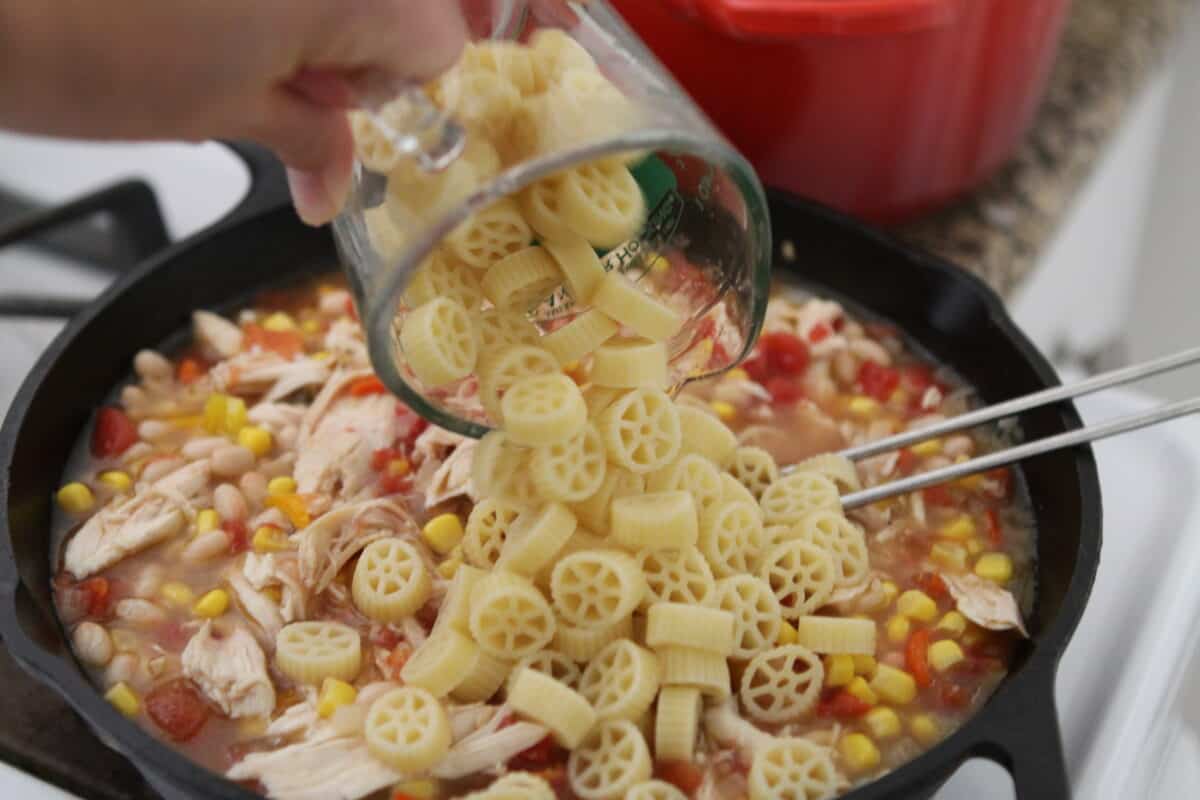 adding cooked pasta to chili mac