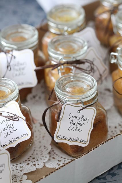 Butter cakes in jars arranged on a tray, labeled with gift tags.