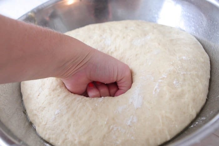 punching down dough in a bowl