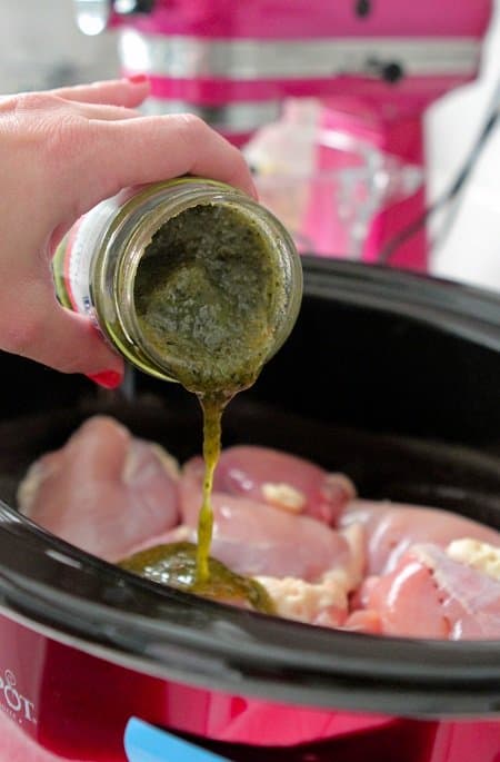 pouring pesto in boneless chicken thigh recipe