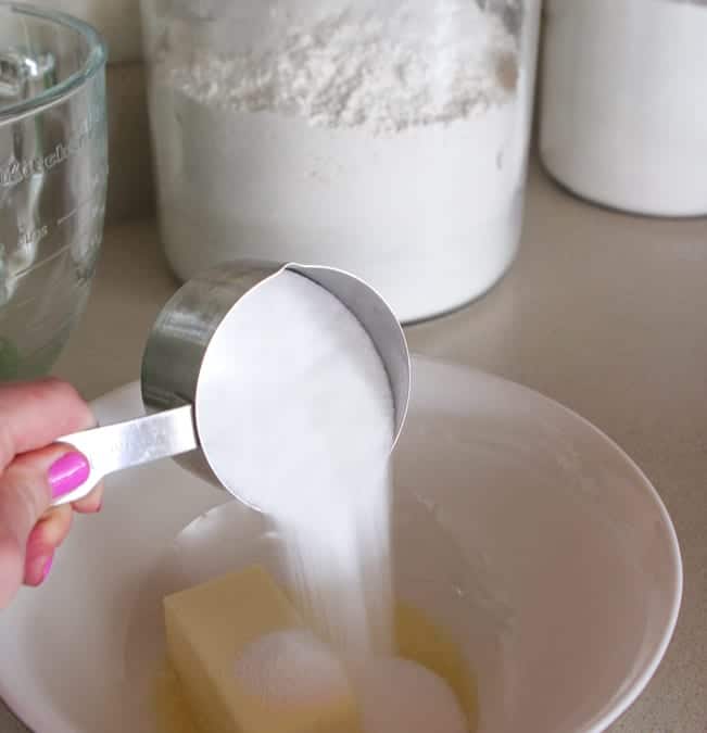 pouring sugar in mixing bowl for cookie bar recipes