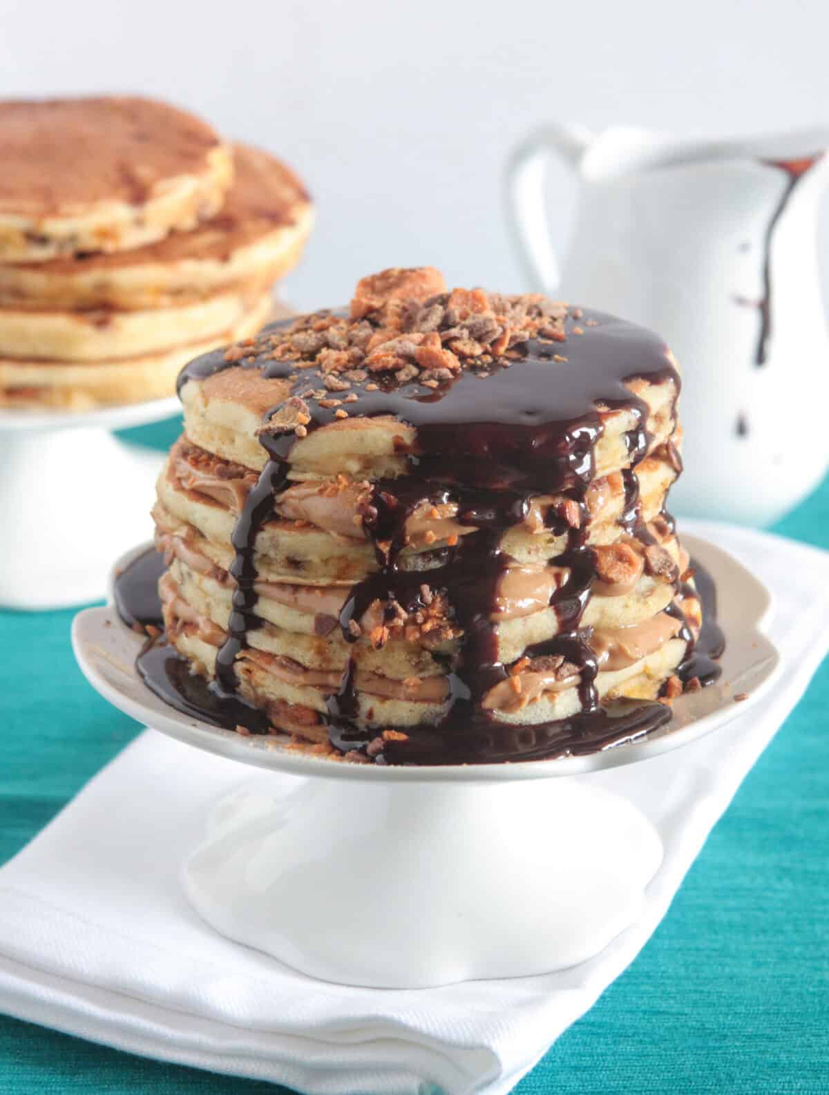 butterfinger peanut butter pancakes stacked on cake stand