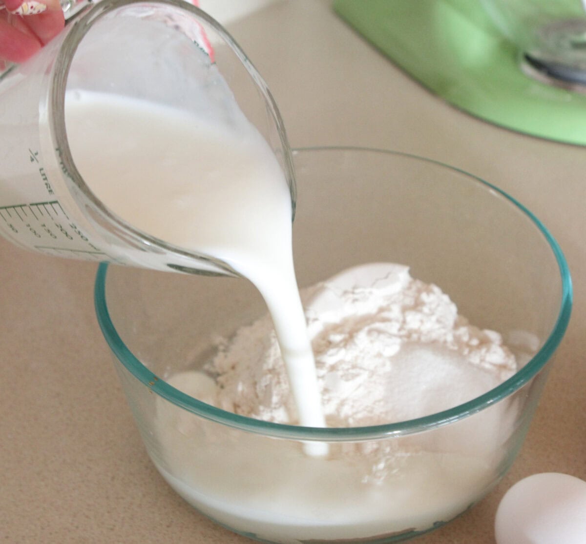 pouring buttermilk into mixing bowl for homemade pancakes