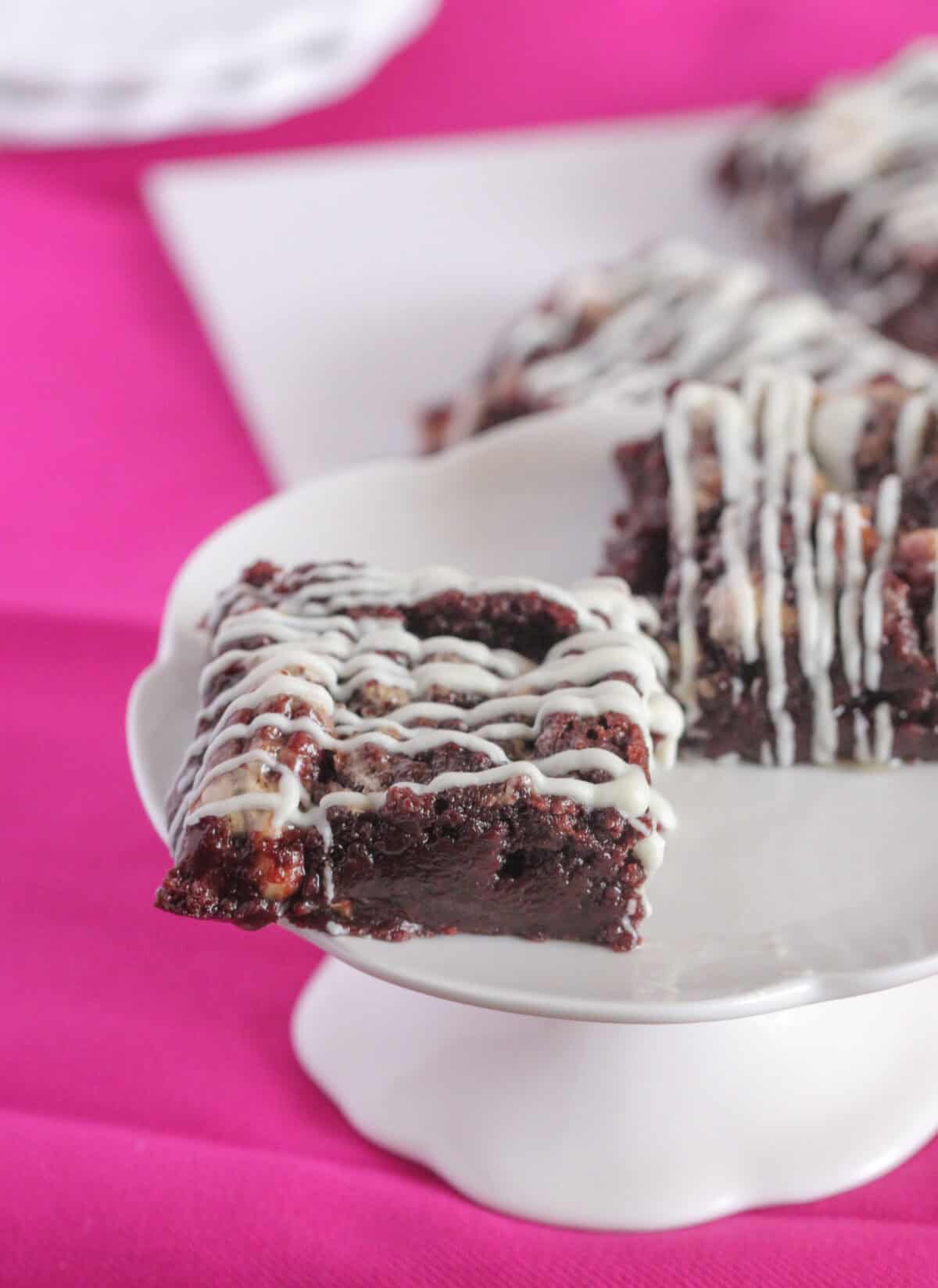 square of pecan brownie on cake stand