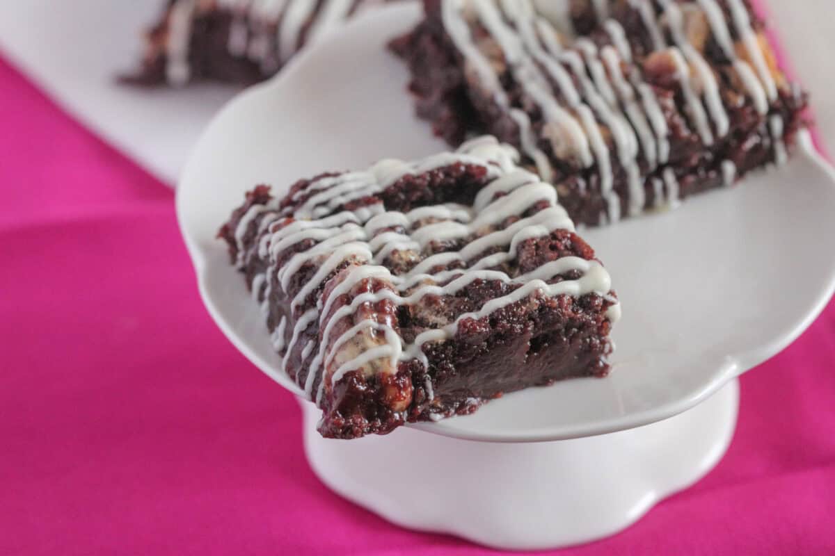 gooey pecan brownie square on cake stand