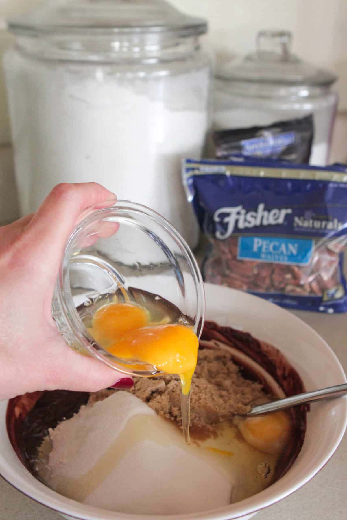 pouring eggs in brownie mixing bowl