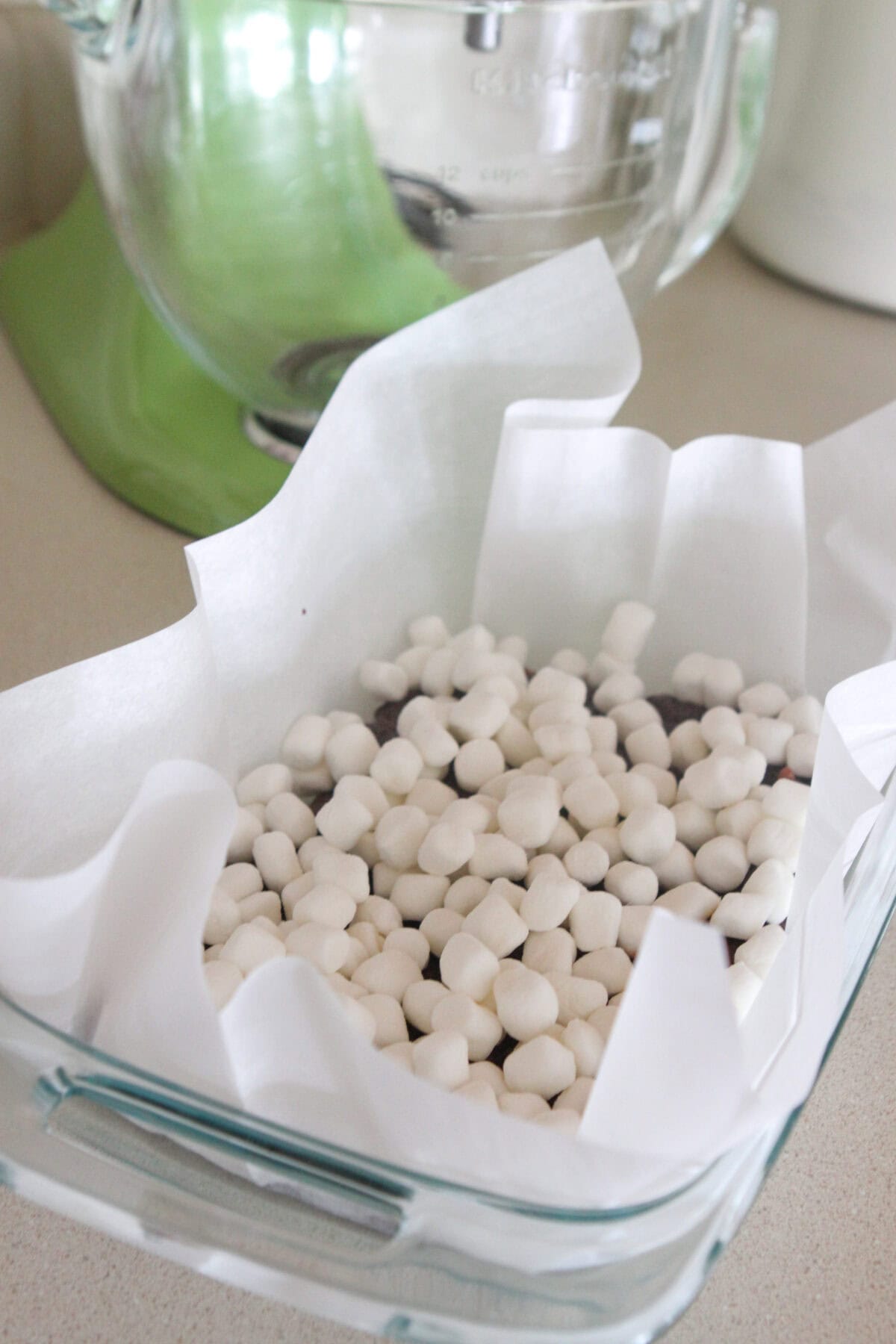 marshmallows added to brownie batter in baking dish