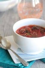 Roasted Broccoli Tomato Soup in a bowl next to a spoon.