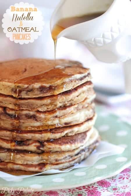 Maple syrup is poured over a stack of banana Nutella oatmeal pancakes.