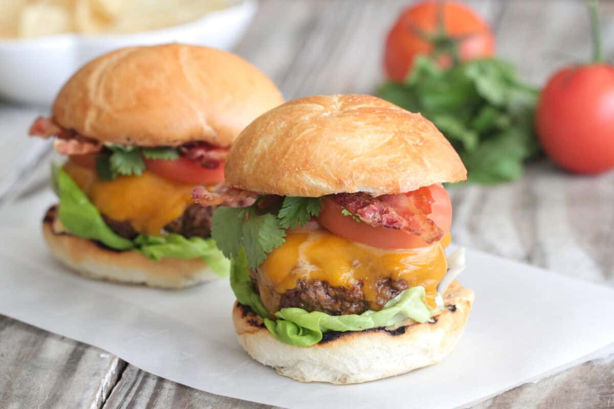 bacon cheeseburgers on parchment paper