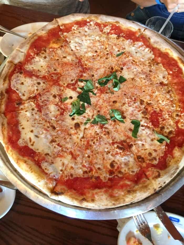 A Sliced Margherita Pizza on a Large Metal Pizza Stand
