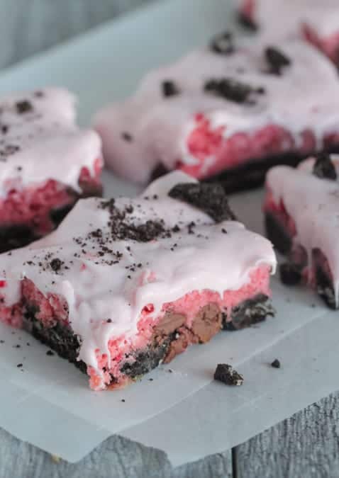 Four Strawberry Cookies and Cream Cake Bars on a Sheet of Parchment Paper