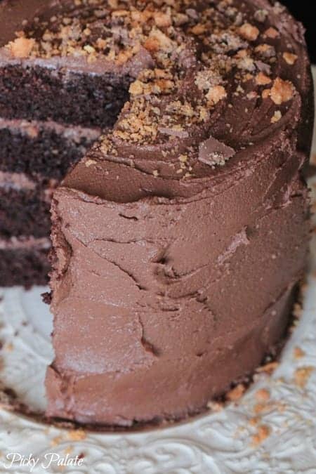 Chocolate Butterfinger layered cake with slices missing to reveal the layers.