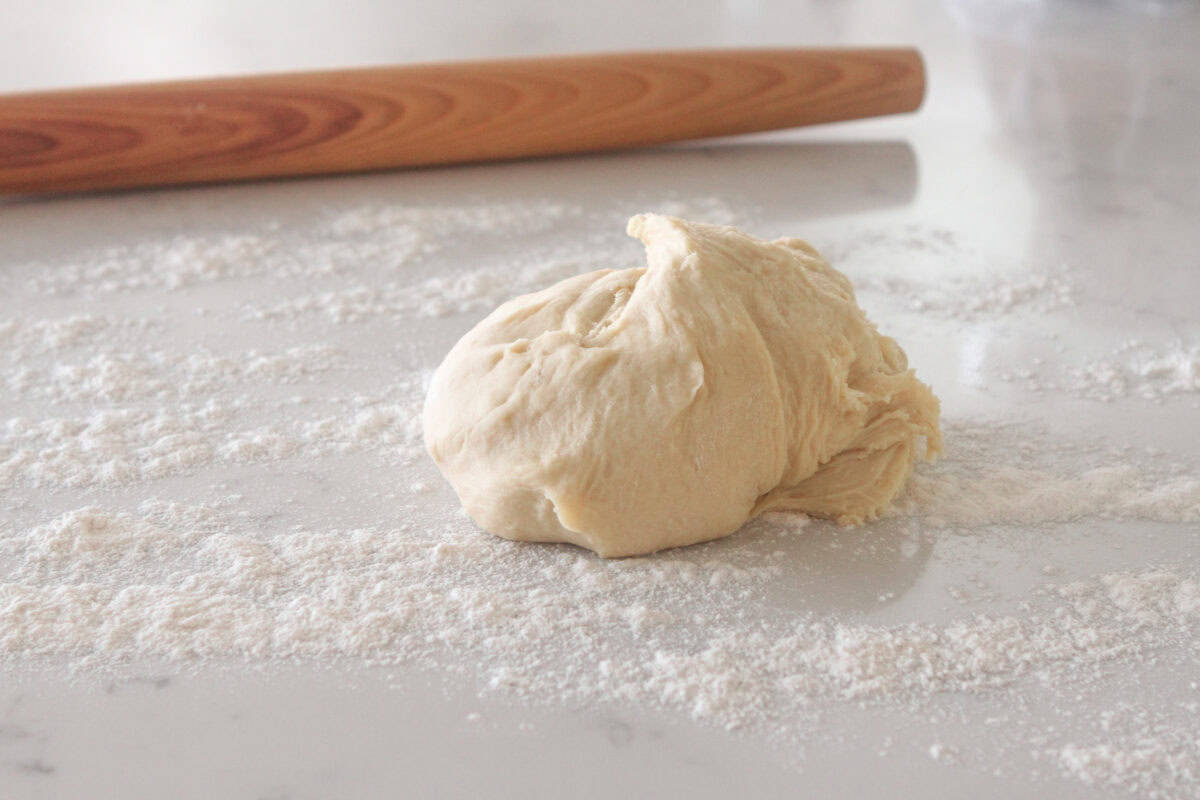 cinnamon roll dough on a floured counter top