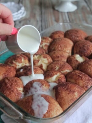 drizzling icing over cinnamon roll bubble bites