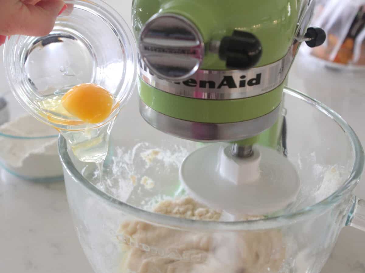 adding egg to stand mixer for cinnamon roll dough