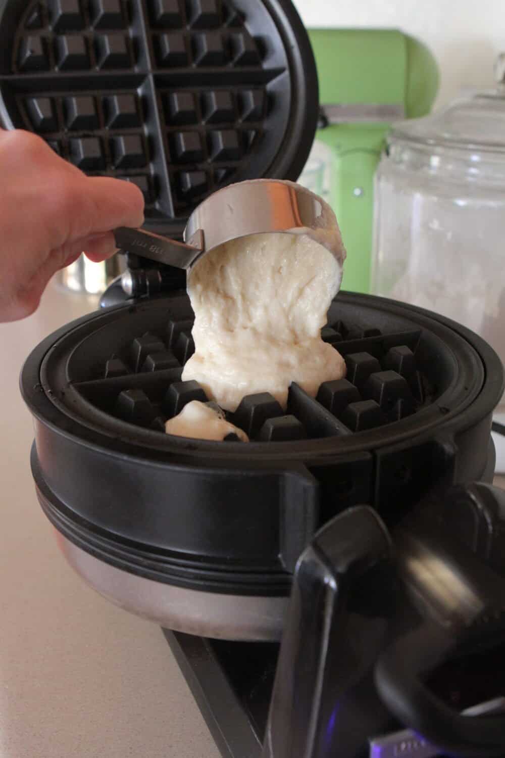 pouring waffle batter into waffle iron