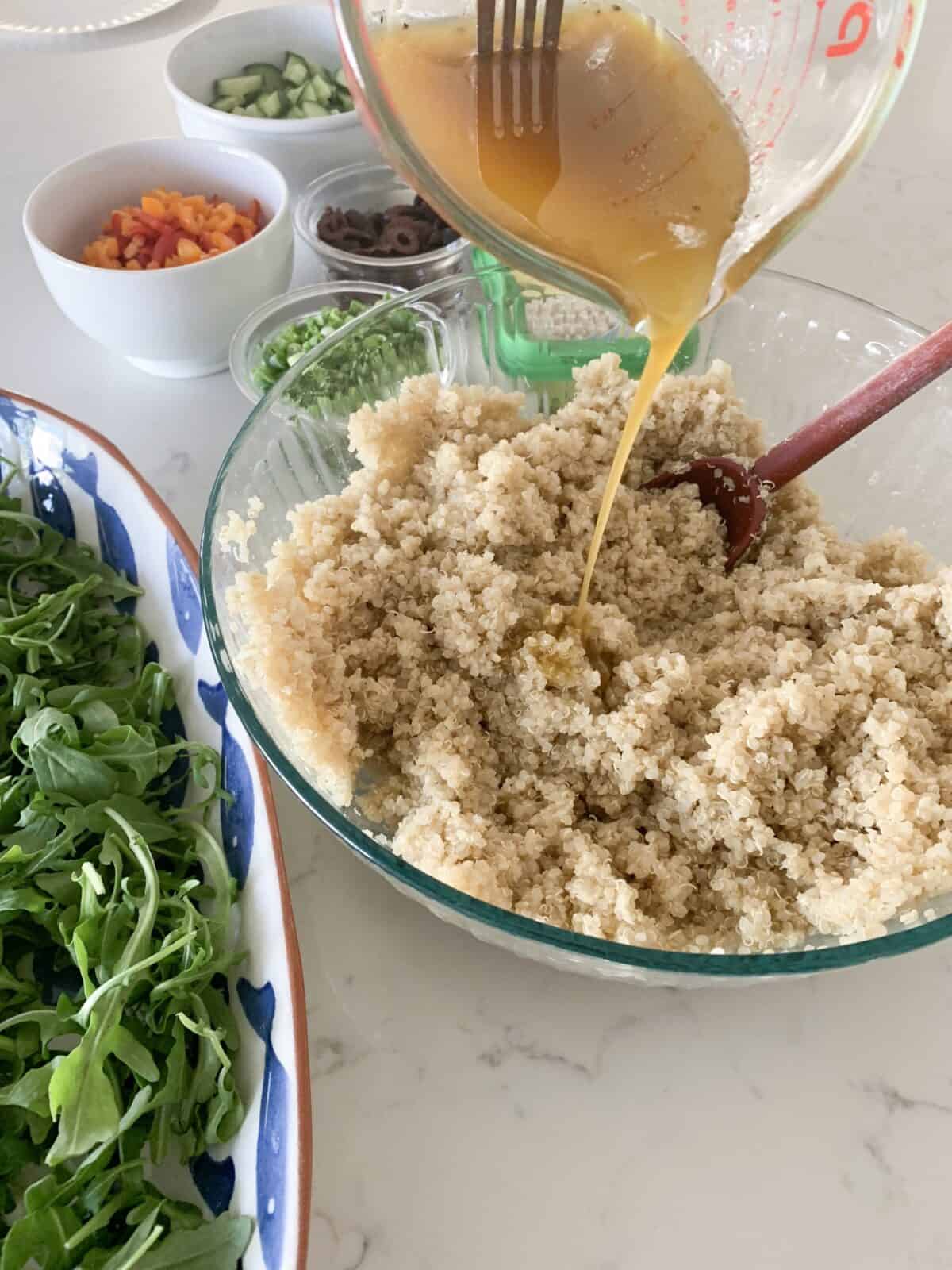pouring dressing over quinoa