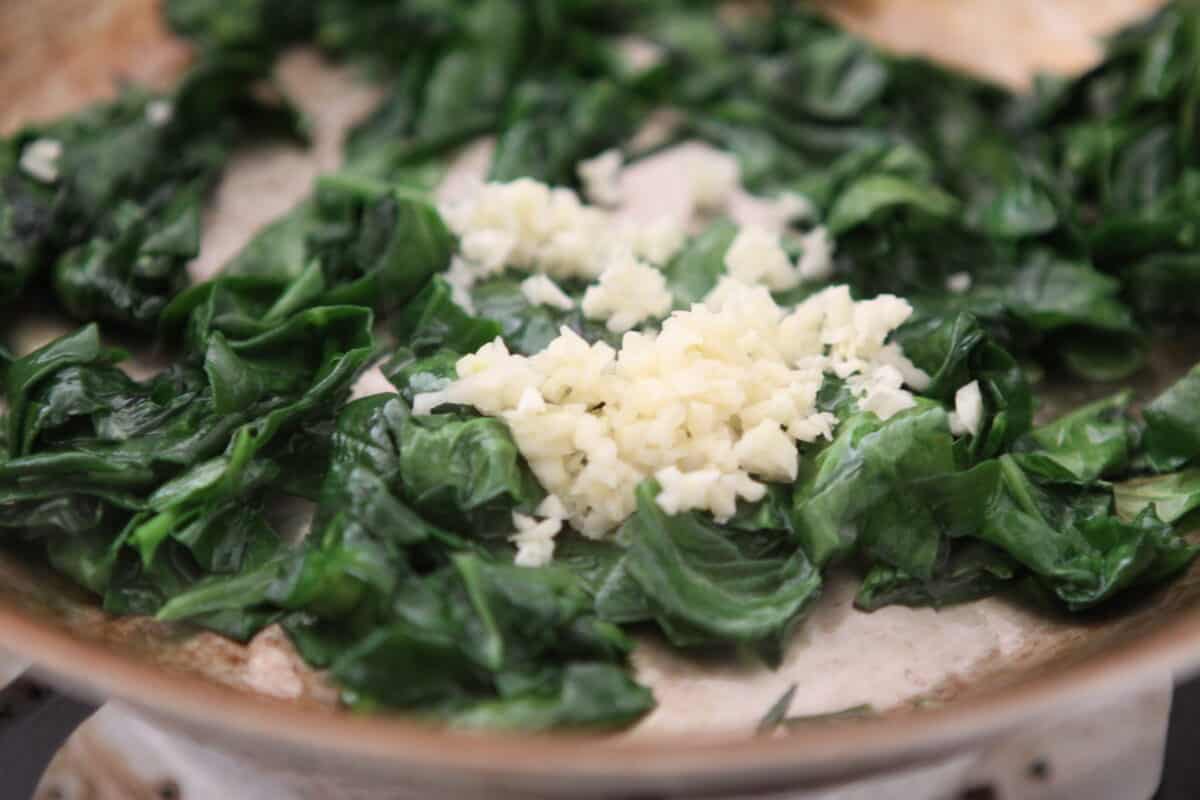 cooking spinach and garlic in skillet