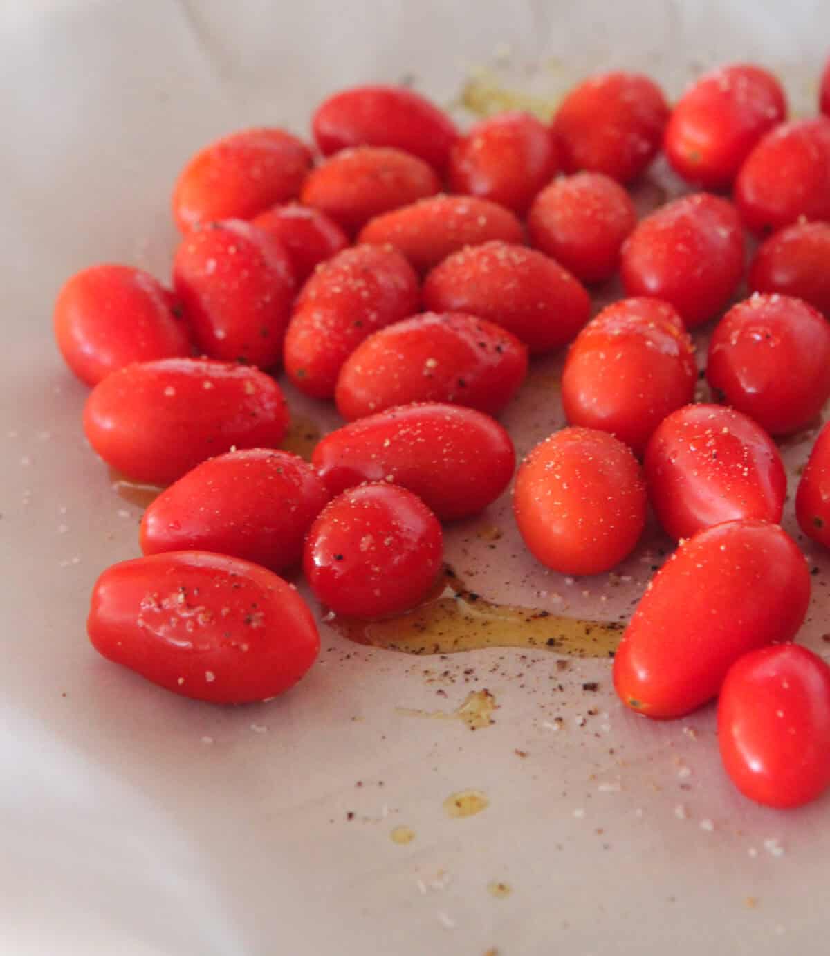 tomatoes on baking sheet with salt and pepper