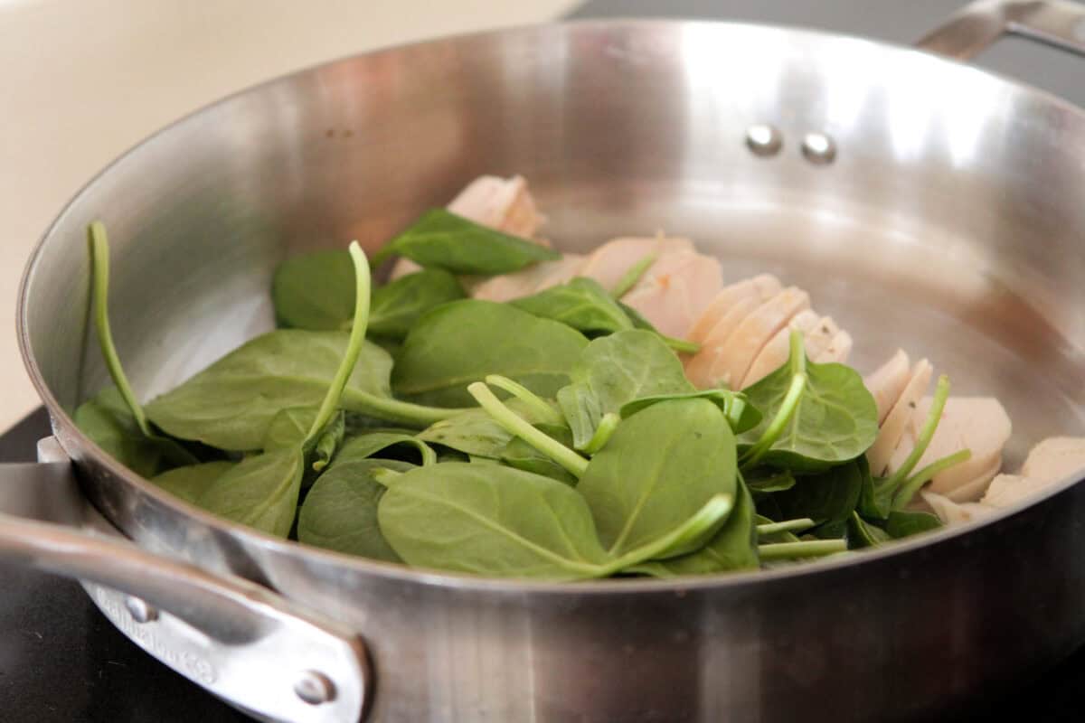 spinach and chicken in large pot cooking