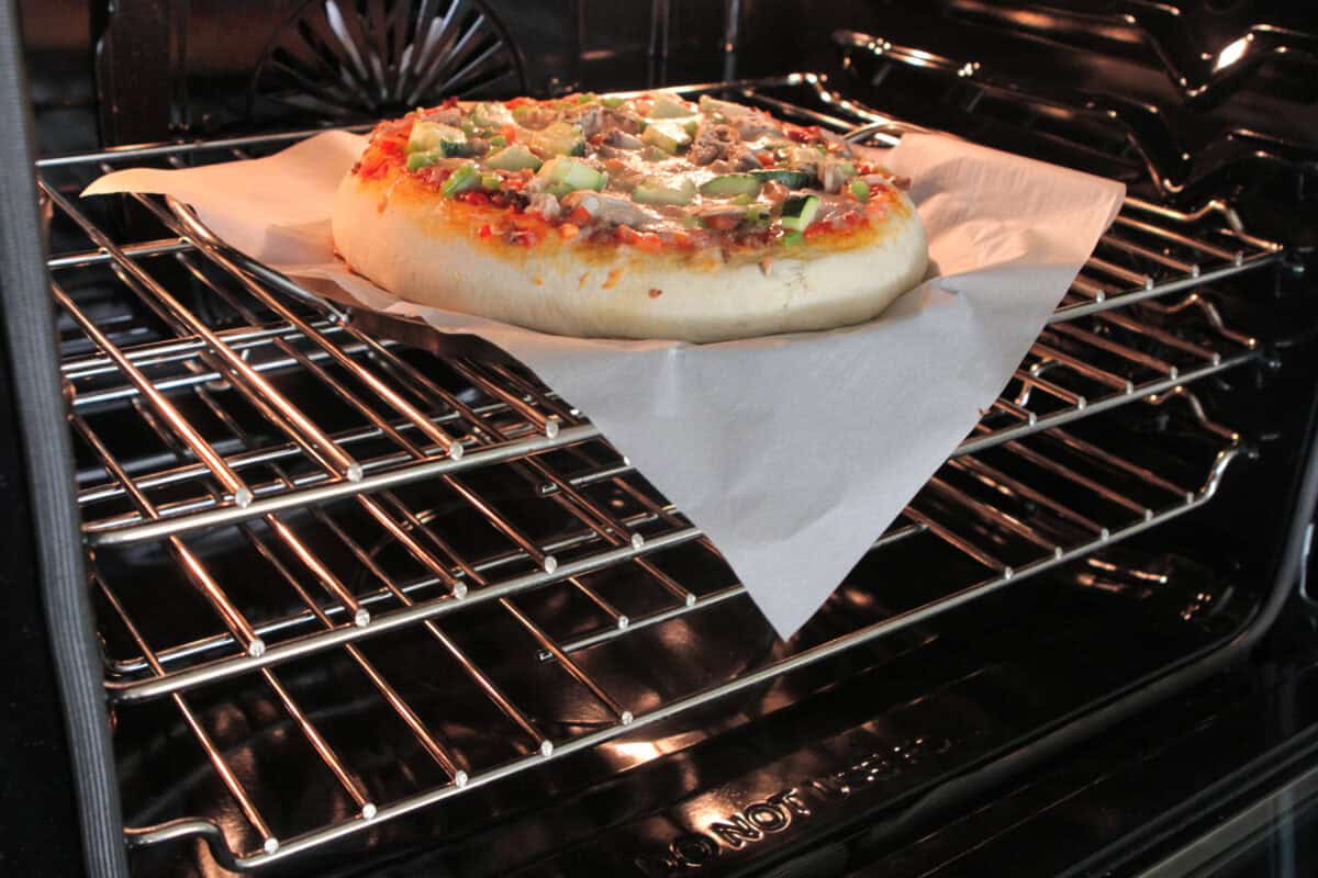 supreme pizza cooking in the oven on pizza pan