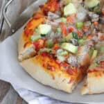 supreme pizza cut into slices on pizza pan