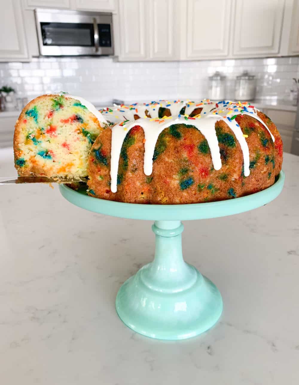 slice of funfetti cake on cake stand
