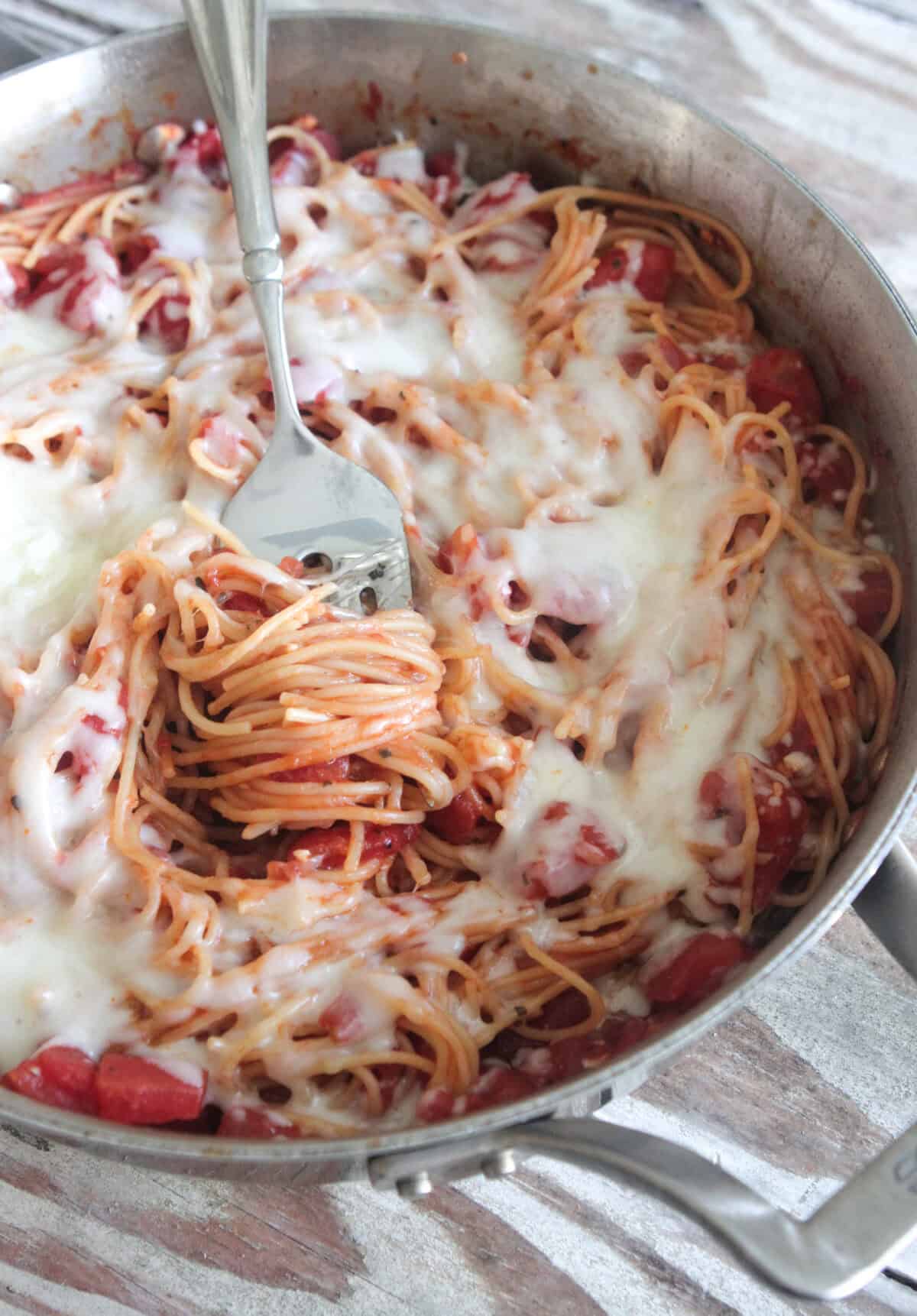 cheesy spaghetti in a serving pot