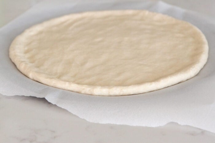 pizza crust rolled into a round on pizza pan