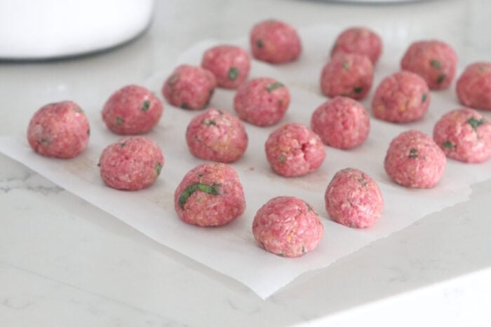 meatballs rolled into balls on parchment paper
