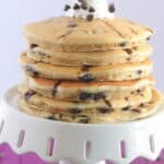 chocolate chip pancakes stacked on a cake stand