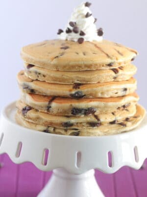chocolate chip pancakes stacked on a cake stand