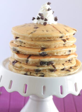 chocolate chip pancakes stacked on a cake stand