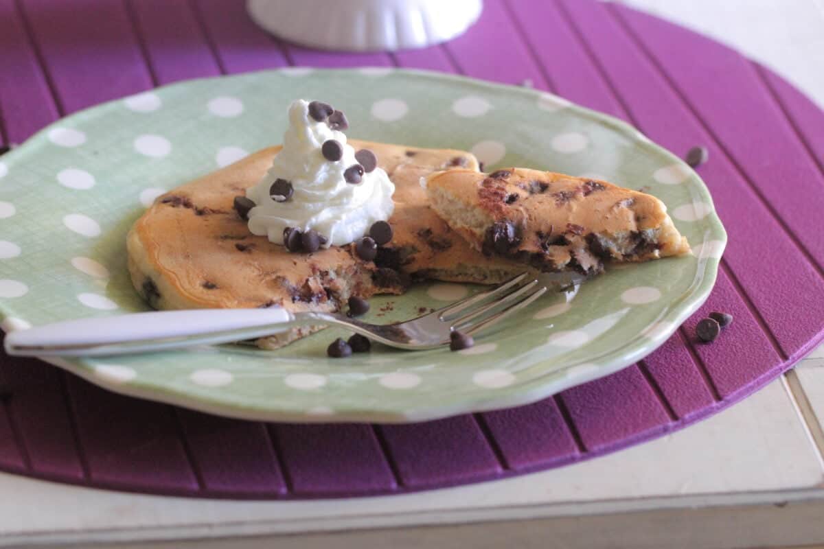 chocolate chip pancake on plate cut with fork
