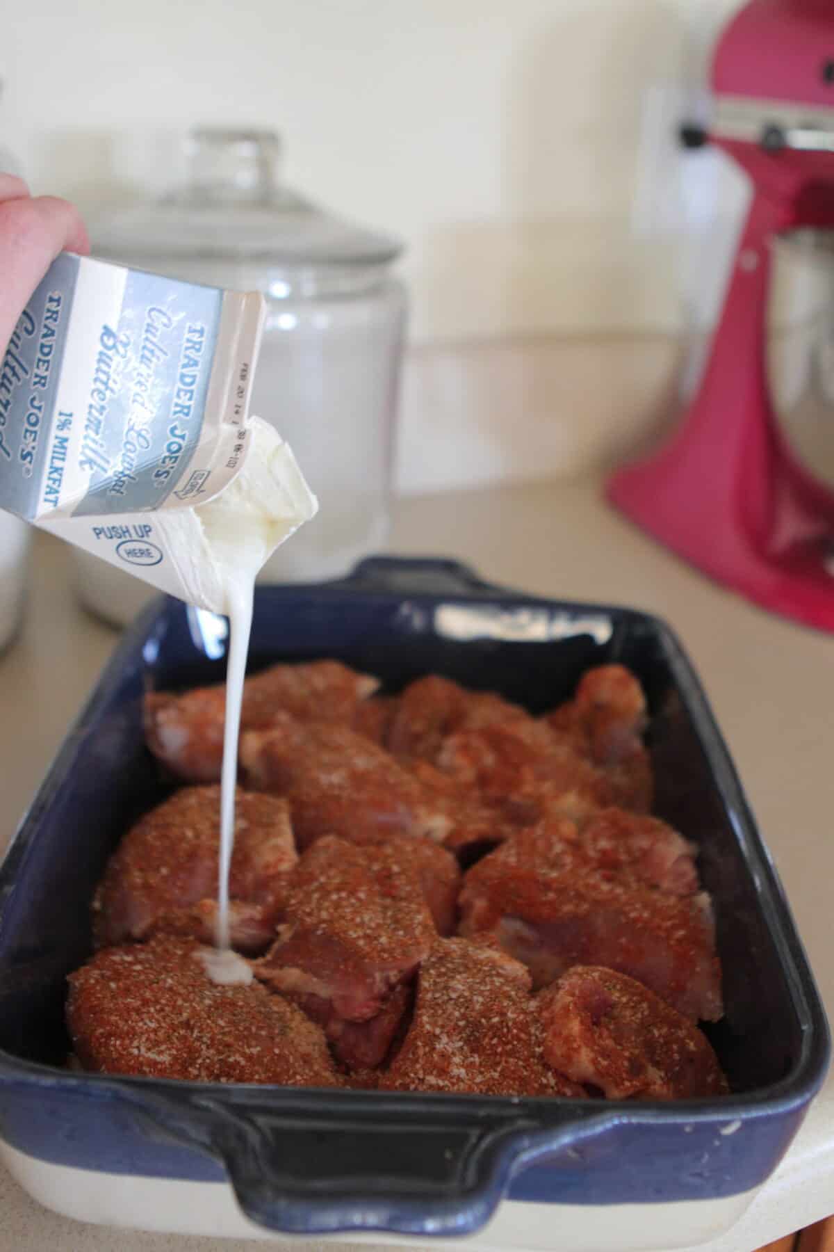 pouring buttermilk over chicken thighs