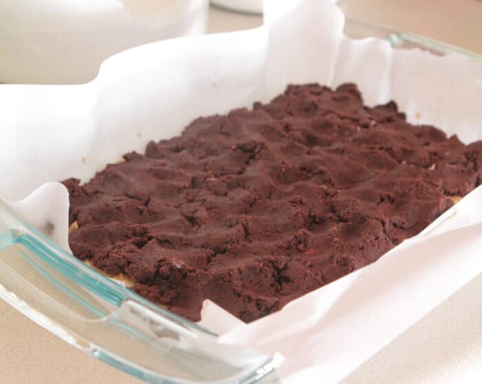 devils food cake dough pressed over peanut butter dough in baking dish
