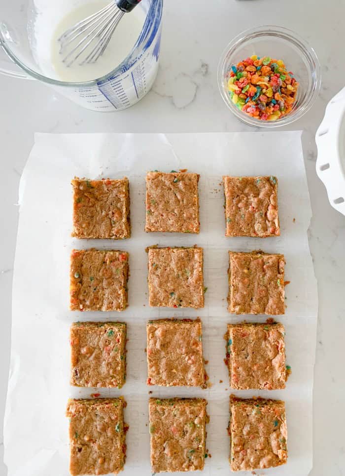 cookie bars cut into squares on parchment paper ready for icing