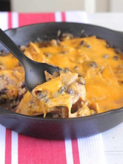 chicken taco bake in cast iron skillet being spooned out