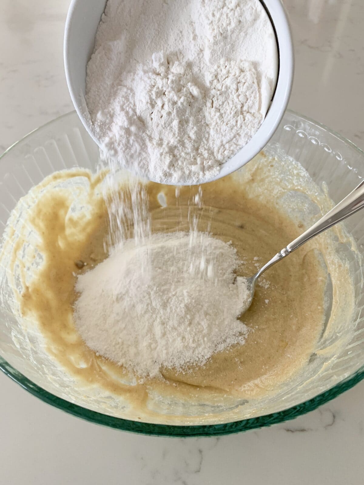 adding flour to mixing bowl of cookie dough