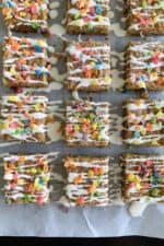 fruity pebbles cookie bars cut into squares on parchment paper