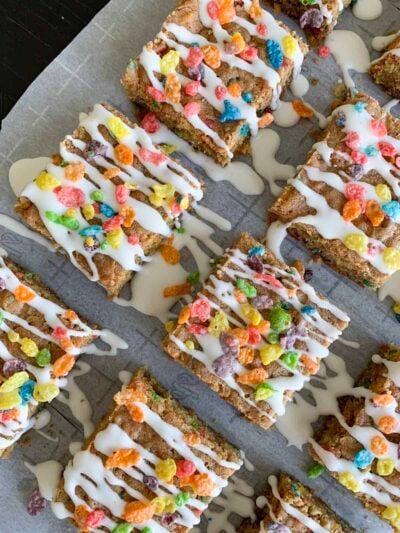 fruity pebbles cookie bars cut into squares on parchment paper