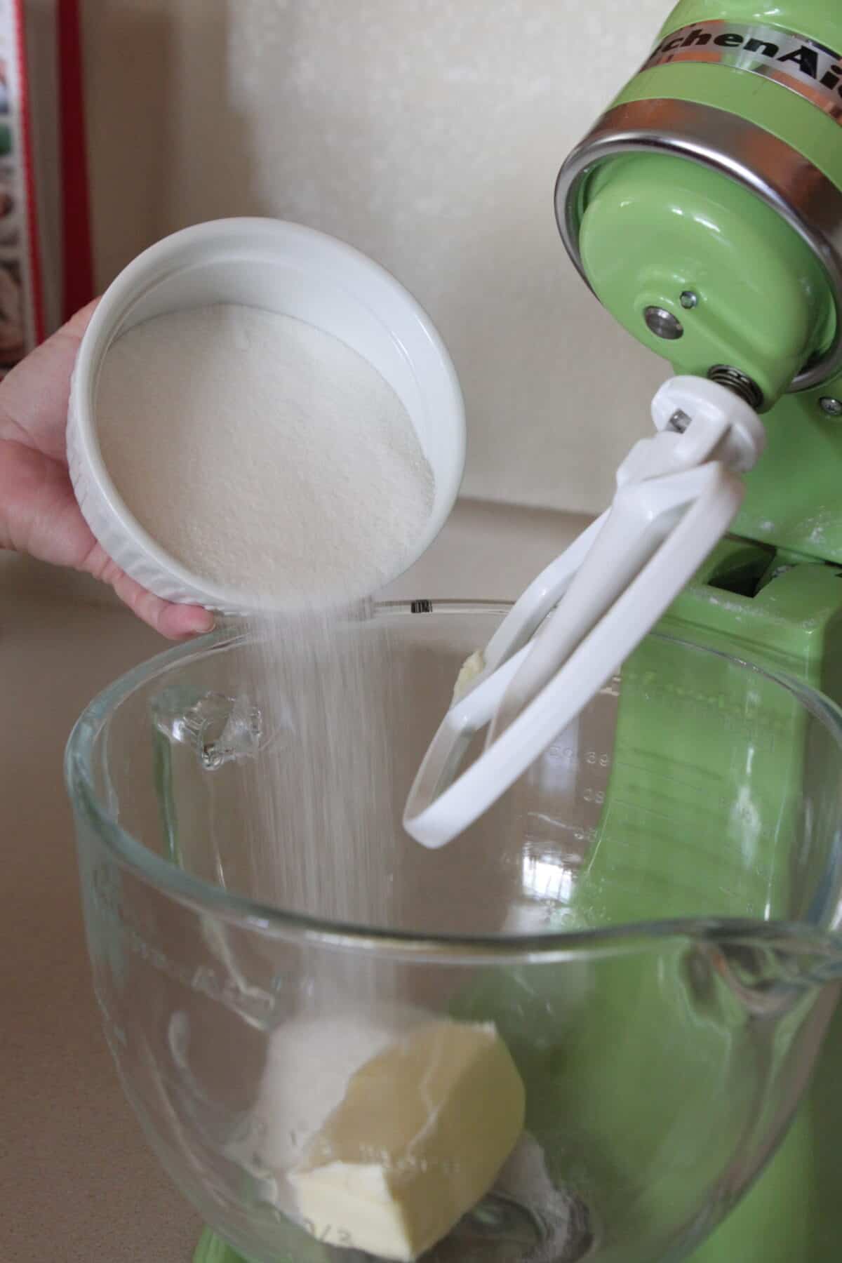 pouring sugar into stand mixer with butter