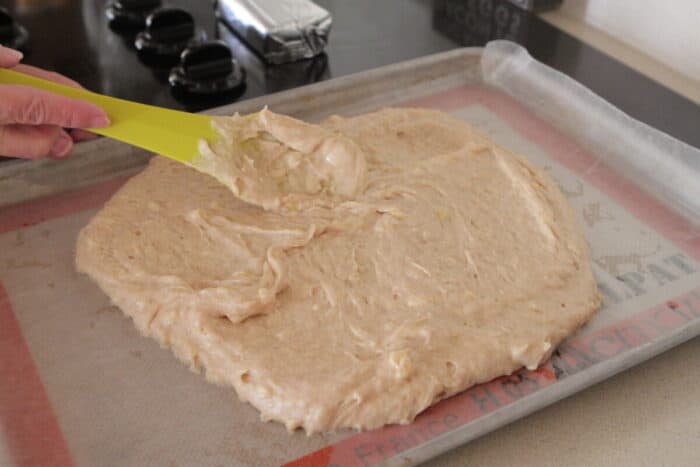 spreading banana sheet cake batter into half sheet pan