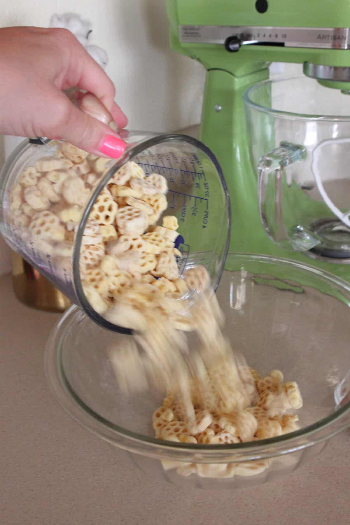 pouring honey comb cereal into large mixing bowl