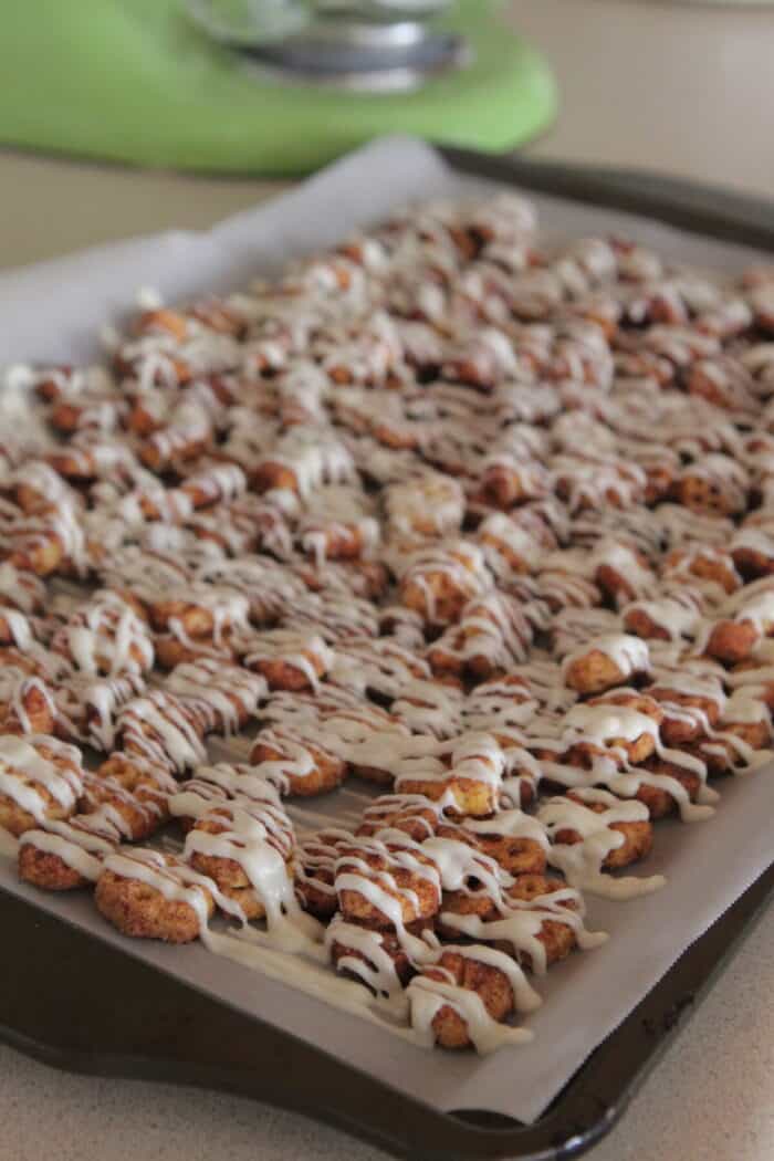 white chocolate drizzled over snack mix on baking sheet